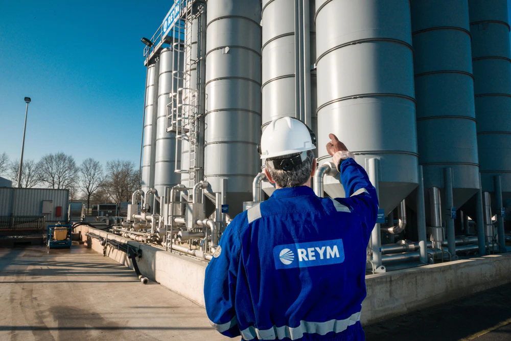 Medewerker van reym gefotografeerd vanaf de rug, voor een aantal sylo's