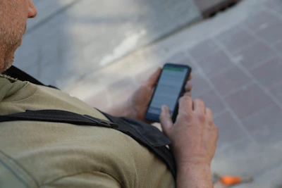 Grondwerker kijkt op mobiele telefoon vanaf bovenaanzichtInkopen tegen de juiste prijs én met een soepele afhandeling