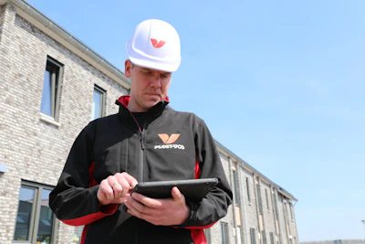 Bouwvakker met helm bekijkt een tabletschermGrafische middelenplanning